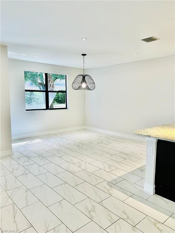 7841 Bristol Circle Naples, FL 34120 - Photo 6 of 31 Unfurnished dining area with light marble finish floors and a chandelier