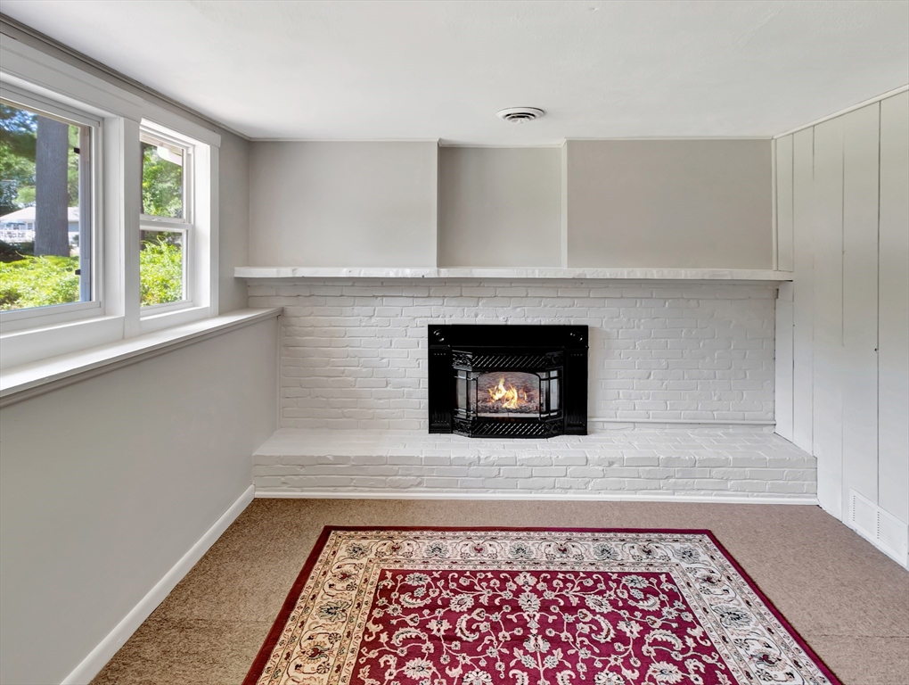 4 Gary Road Norton, MA 02766 - Photo 32 of 42 a living room with a fireplace and a rug