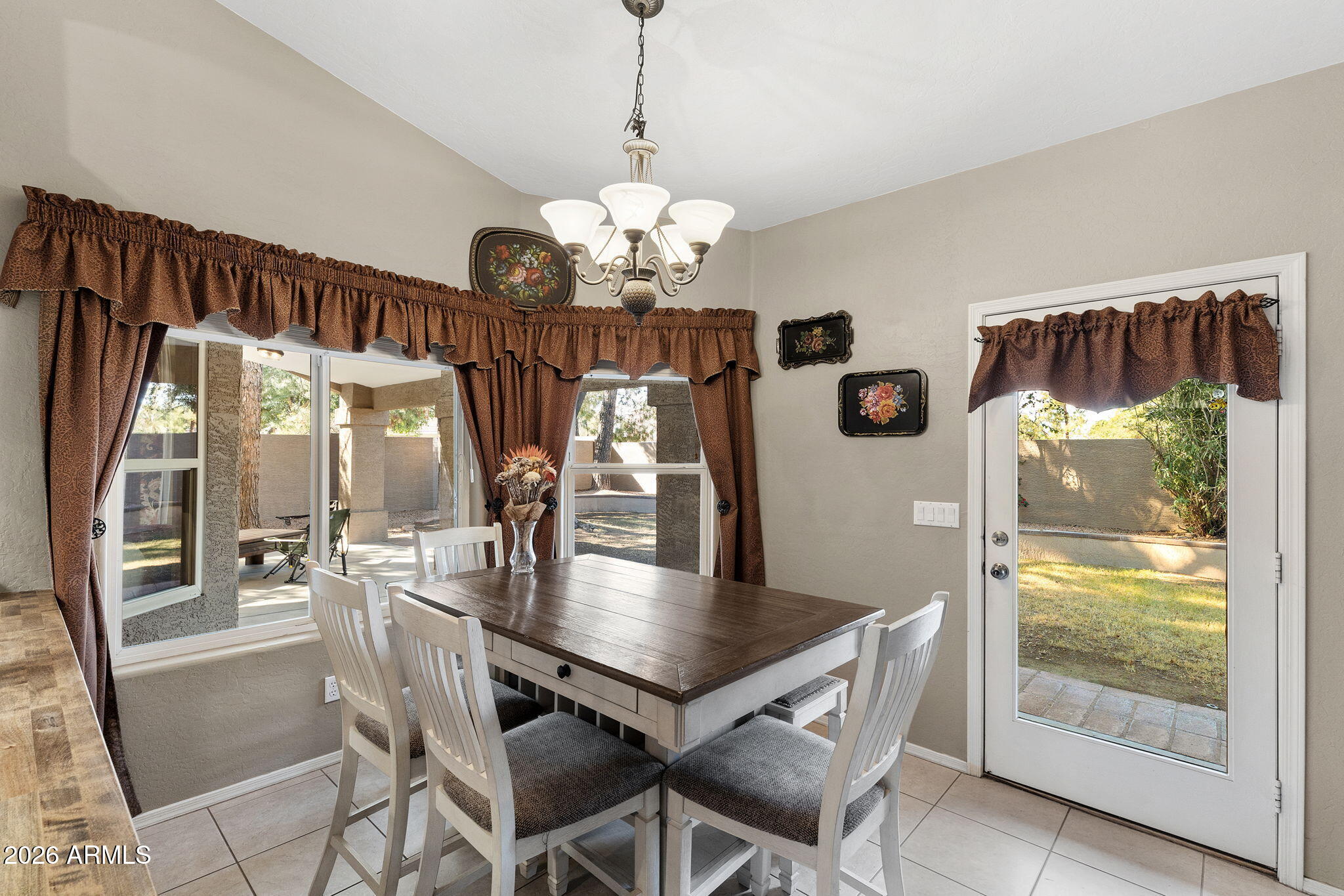 844 North Oracle Circle Mesa, AZ 85203 - Photo 11 of 34 a dining room with wooden floor a chandelier a wooden table and chairs