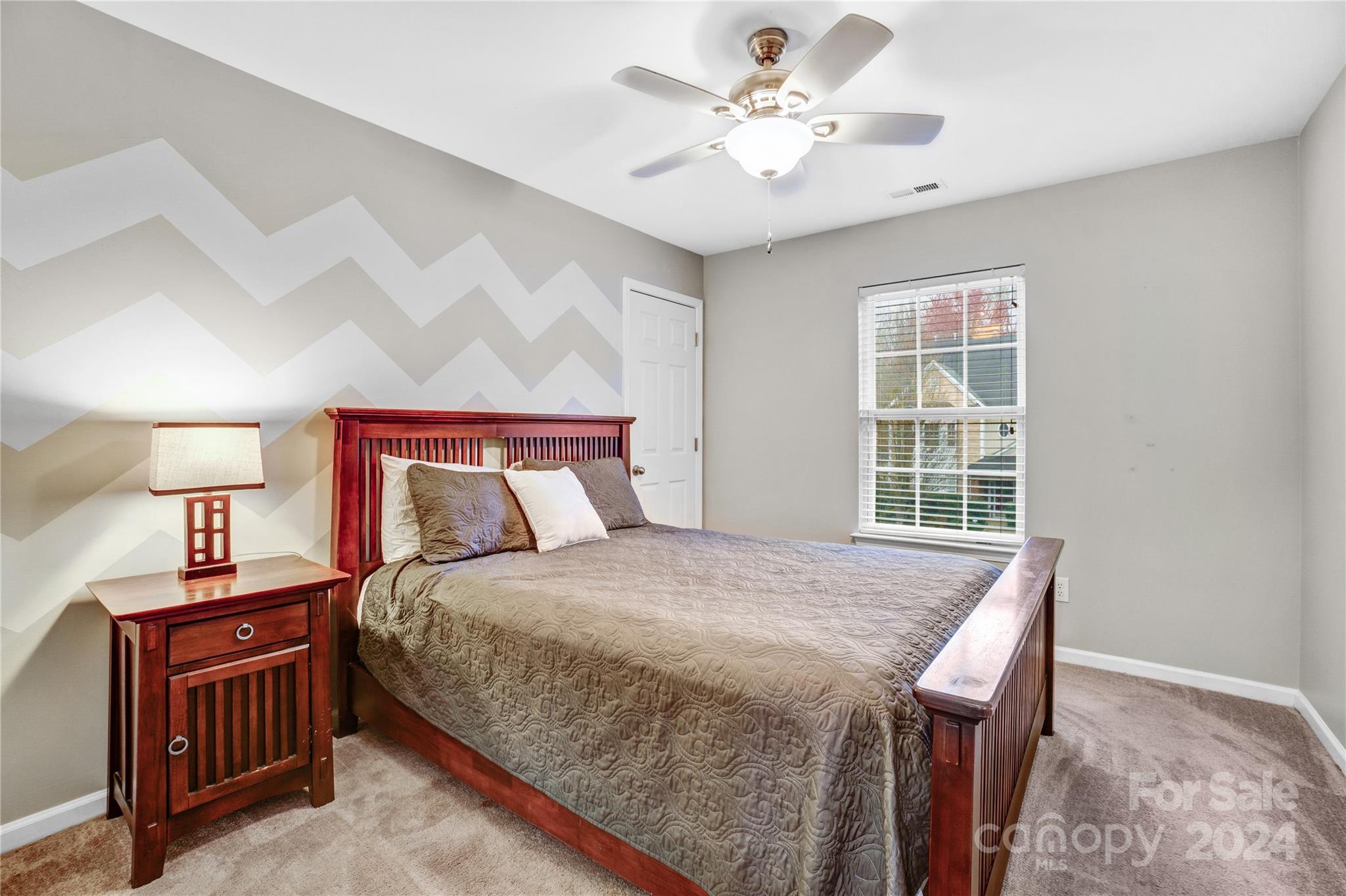 14432 Whistling Swan Road Charlotte, NC 28278 - Photo 19 of 28 a bedroom with a bed and a chandelier
