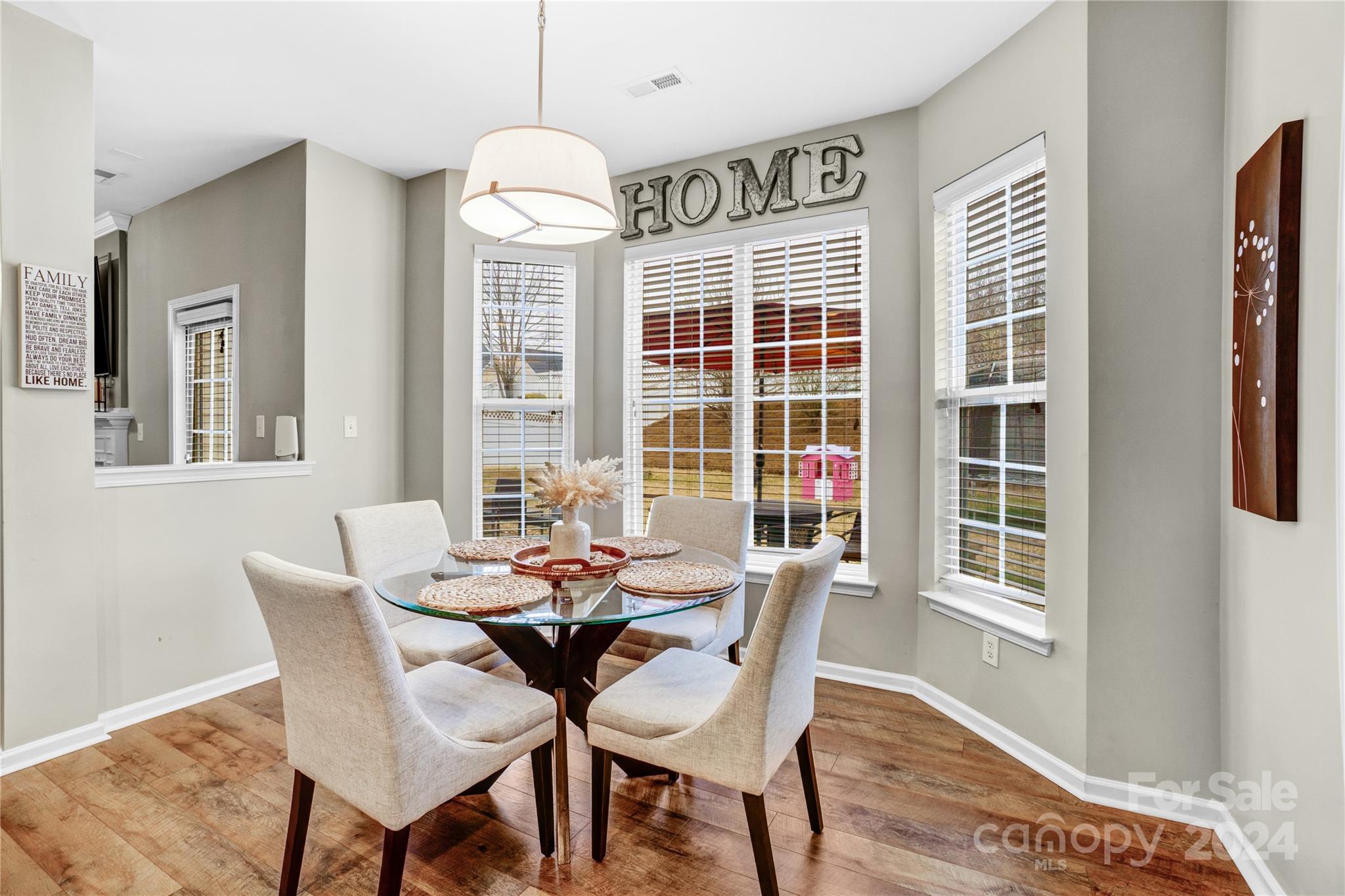 14432 Whistling Swan Road Charlotte, NC 28278 - Photo 9 of 28 a dining room with furniture a chandelier and wooden floor