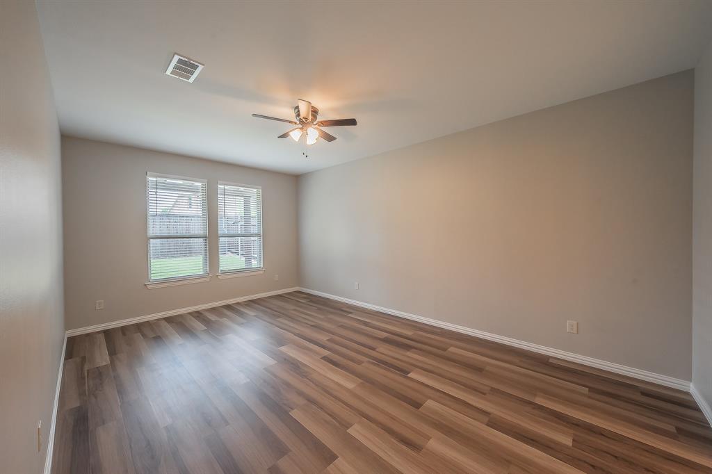 412 Hideaway Road McKinney, TX 75072 - Photo 17 of 40 a view of an empty room with a window and wooden floor