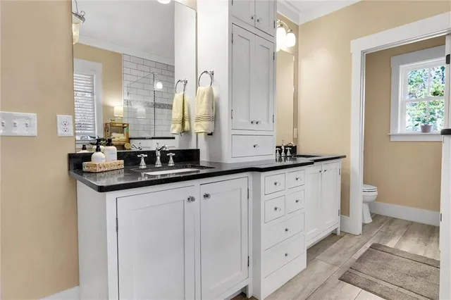 a bathroom with a sink a toilet and a mirror