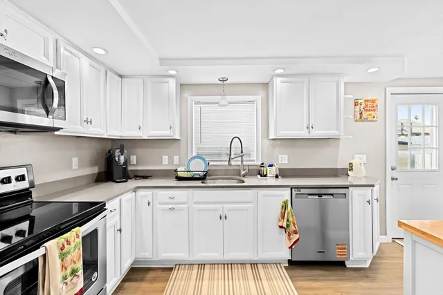 a kitchen with stainless steel appliances granite countertop a sink stove and cabinets