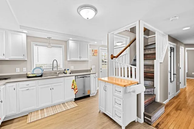 a hallway with cabinets a sink and a stove
