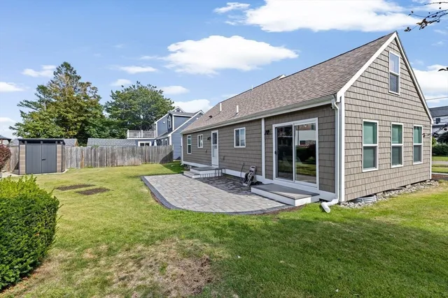 a view of a house with backyard and sitting area
