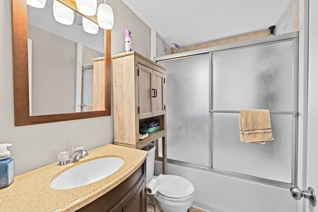 a bathroom with a sink toilet a mirror and shower