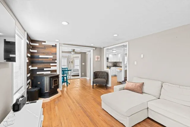 a living room with furniture large window and wooden floor