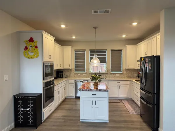 a kitchen with a refrigerator and a stove top oven