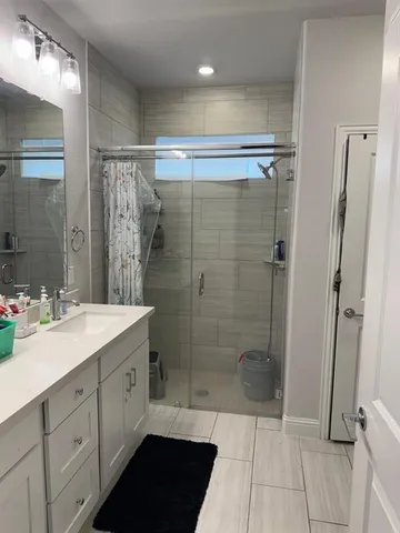 a bathroom with a shower sink and mirror