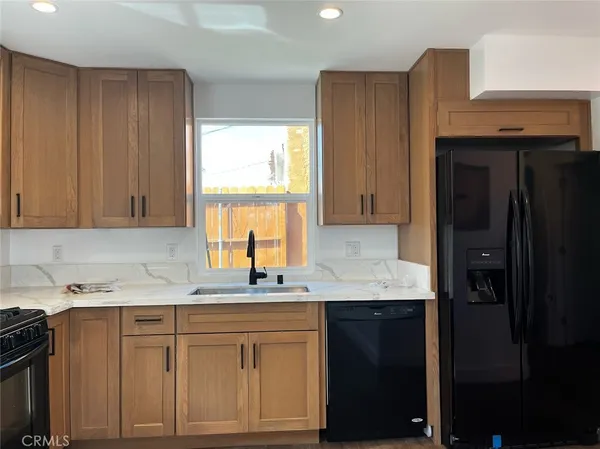 a kitchen with granite countertop cabinets sink and window