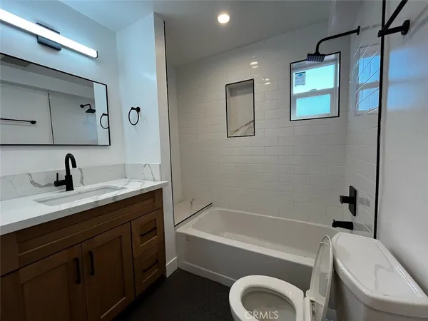 a bathroom with a tub sink toilet and mirror