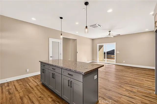 a kitchen with granite countertop a sink cabinets and wooden floor