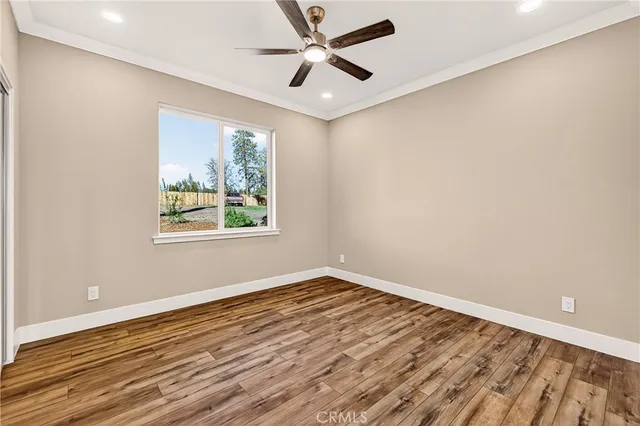 an empty room with window and ceiling fan