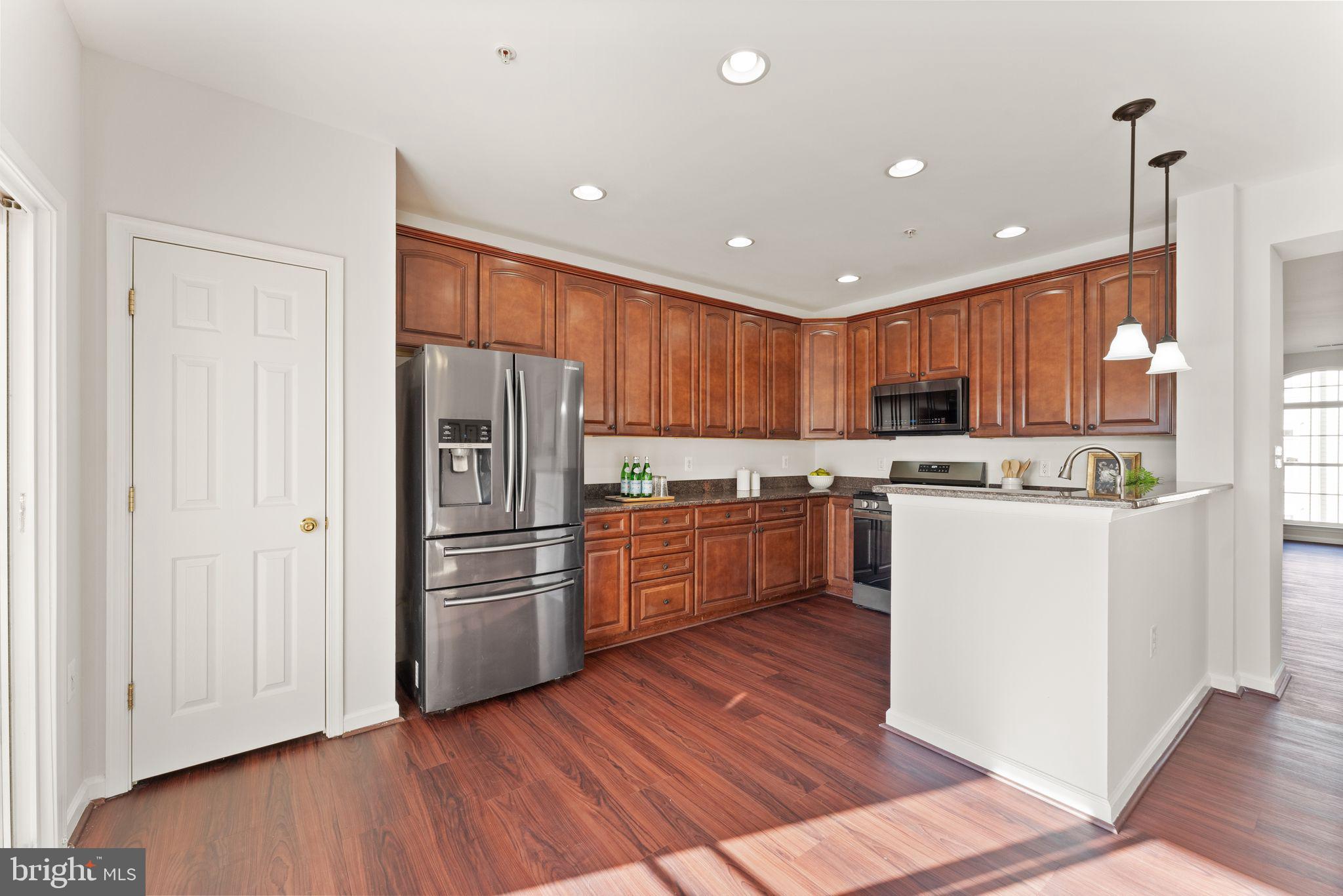 6072 Wicker Lane, Unit 160 Centreville, VA 20121 - Photo 21 of 58 a kitchen with kitchen island wooden floors stainless steel appliances and cabinets