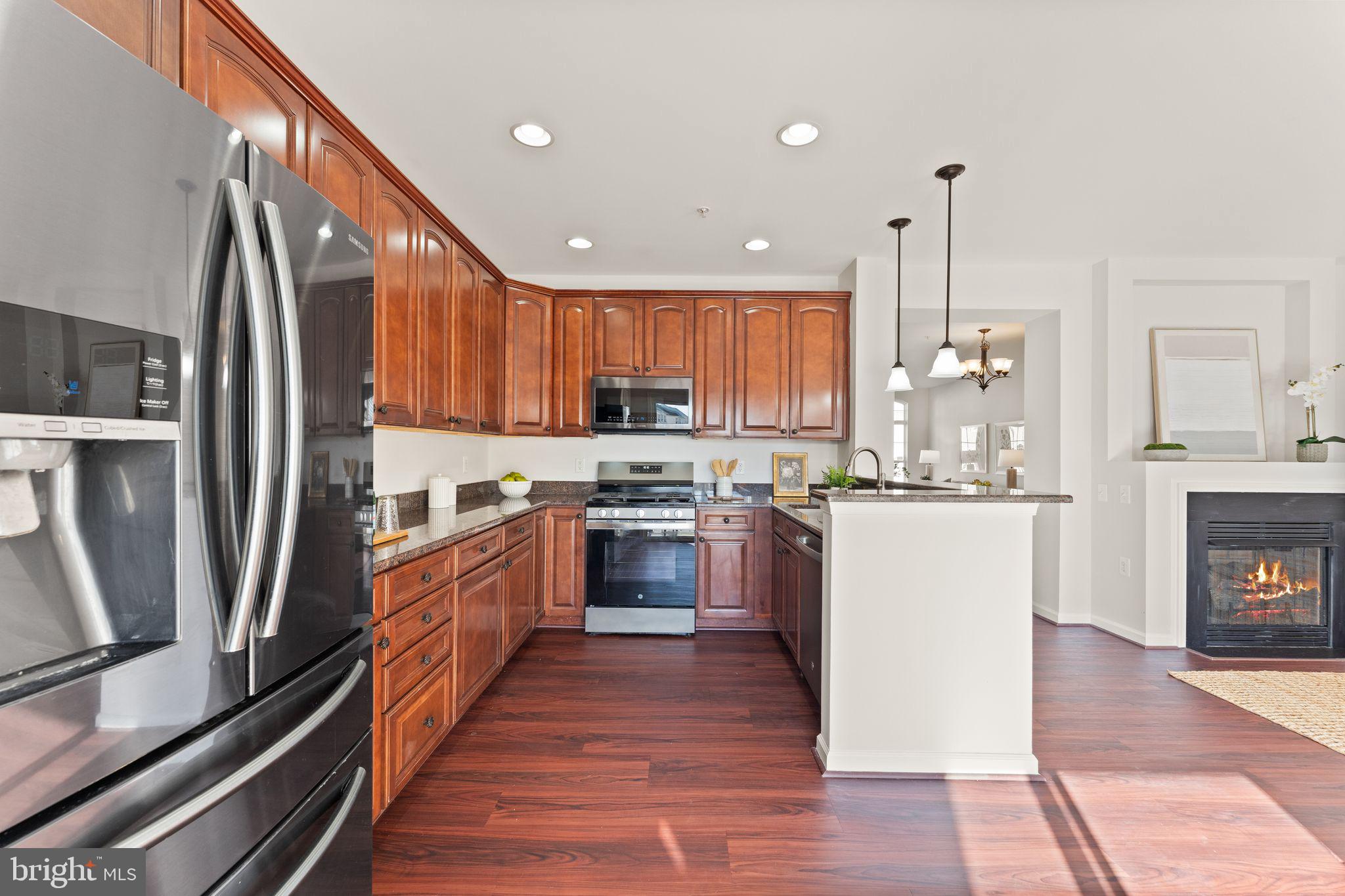 6072 Wicker Lane, Unit 160 Centreville, VA 20121 - Photo 22 of 58 a kitchen with stainless steel appliances granite countertop a refrigerator a sink dishwasher and a stove with wooden floor