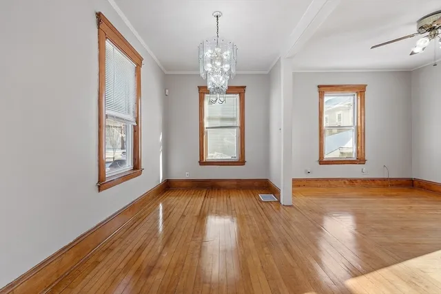 a view of empty room with wooden floor