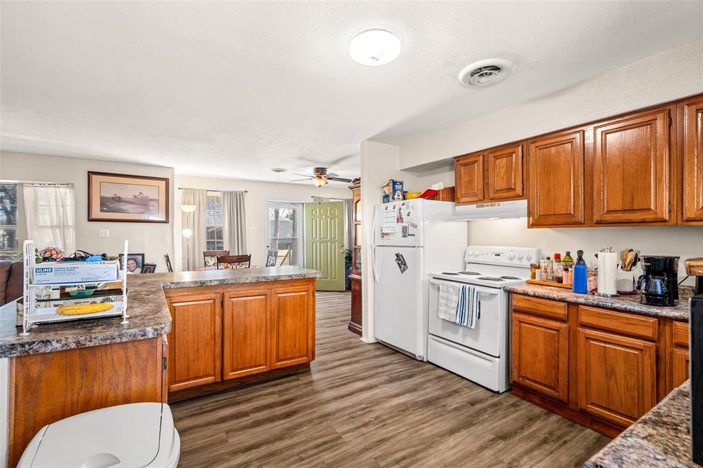 1809 Beverly Street Irving, TX 75061 - Photo 17 of 24 a kitchen with stainless steel appliances a stove a sink dishwasher and wooden cabinets with wooden floor