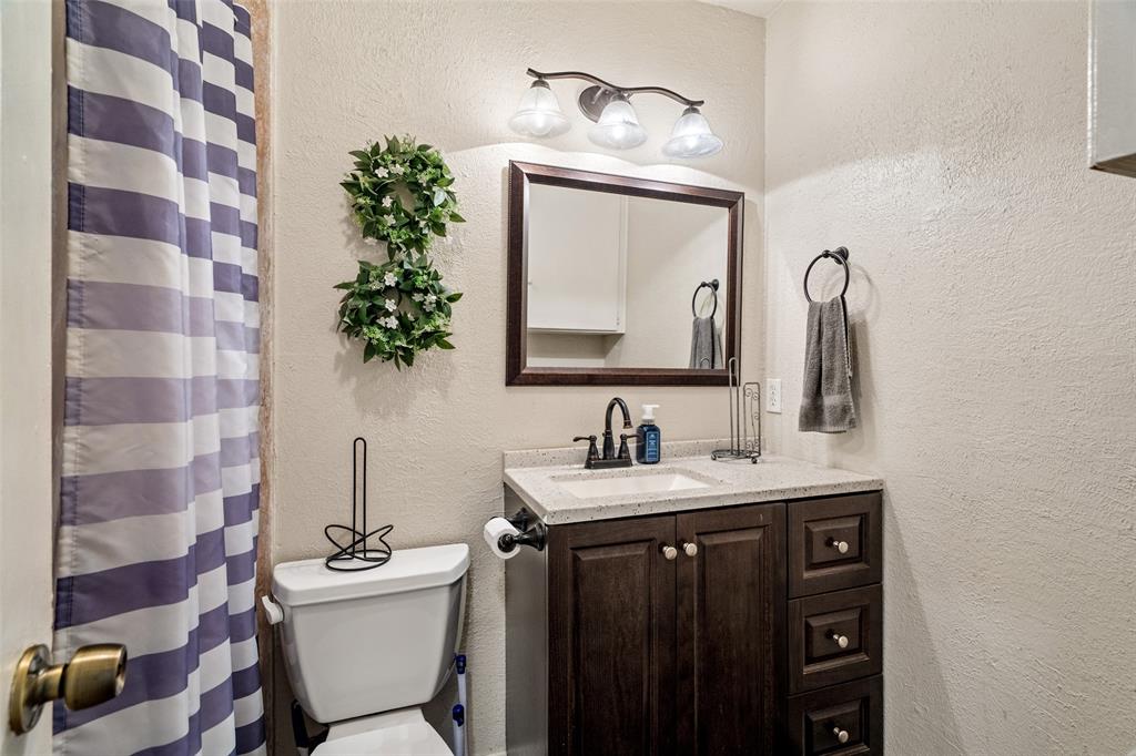 1809 Beverly Street Irving, TX 75061 - Photo 24 of 24 a bathroom with a toilet a sink and mirror