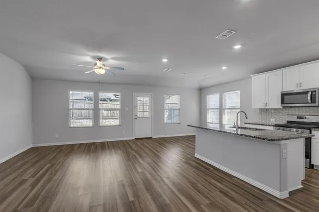 a view of a kitchen sink and microwave with wooden floor