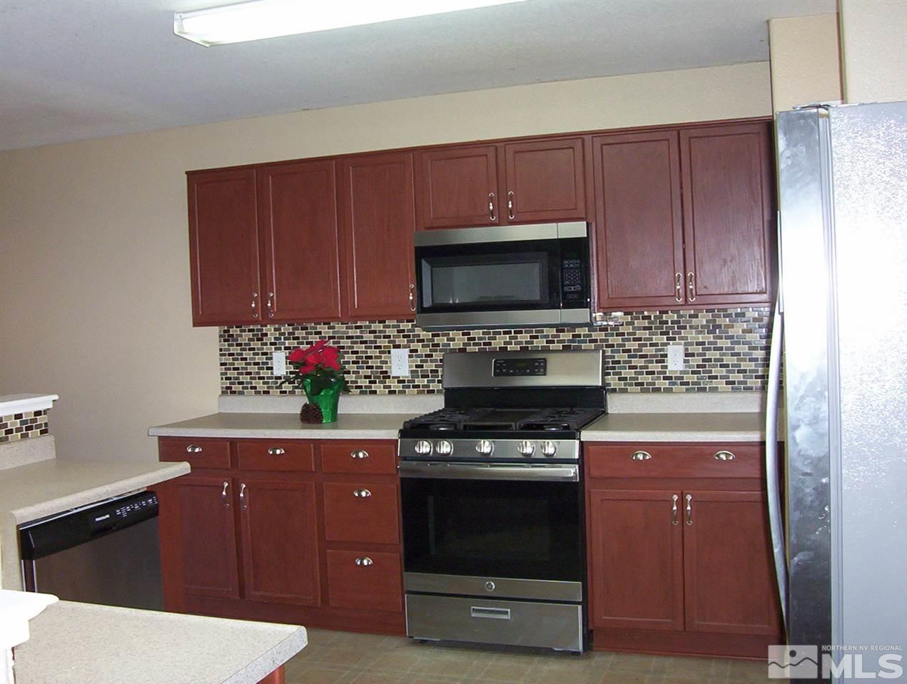 7695 Corso Street Reno, NV 89506 - Photo 5 of 25 a kitchen with a stove microwave and cabinets