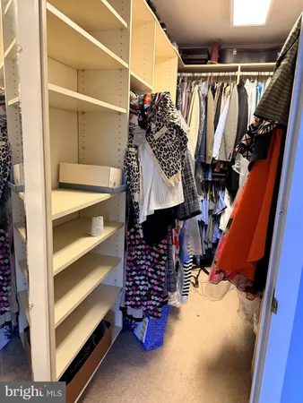 a view of walk in closet with clothes and shoes