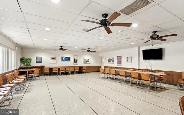 a dining hall with stainless steel appliances granite countertop a sink and a granite counter tops with a large window