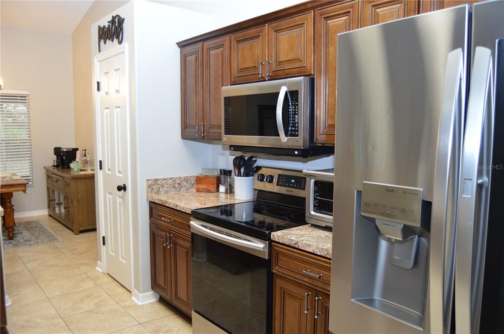 2291 Danforth Road Spring Hill, FL 34608 - Photo 22 of 57 a kitchen with a refrigerator stove and cabinets