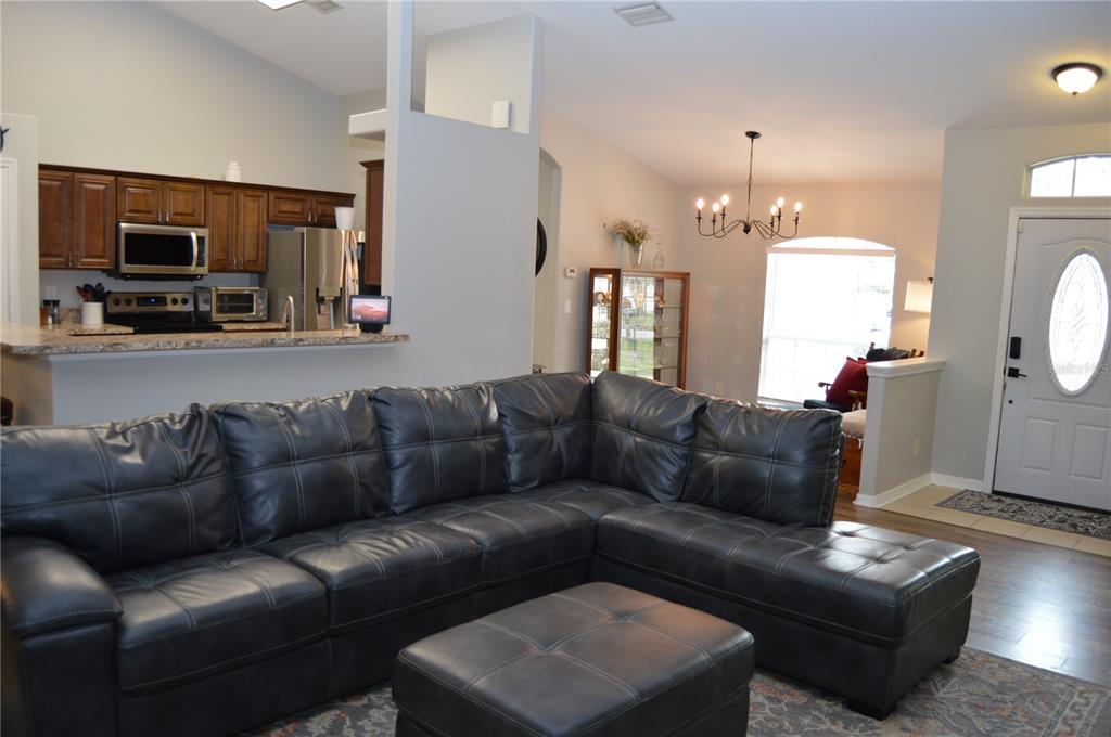 2291 Danforth Road Spring Hill, FL 34608 - Photo 29 of 57 a living room with furniture a flat screen tv and kitchen view