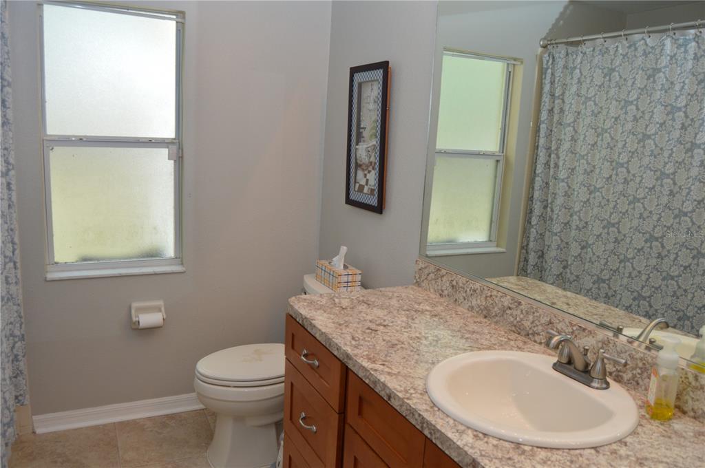 2291 Danforth Road Spring Hill, FL 34608 - Photo 38 of 57 a bathroom with a granite countertop sink a toilet and a mirror