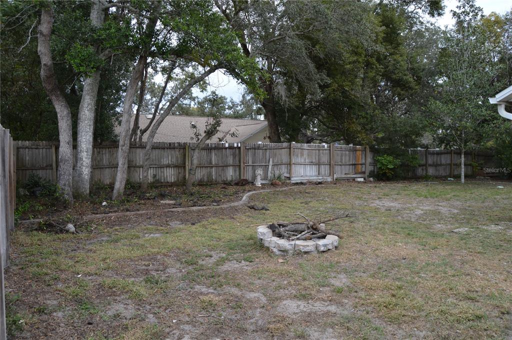 2291 Danforth Road Spring Hill, FL 34608 - Photo 52 of 57 a view of a backyard with a trees and wooden fence