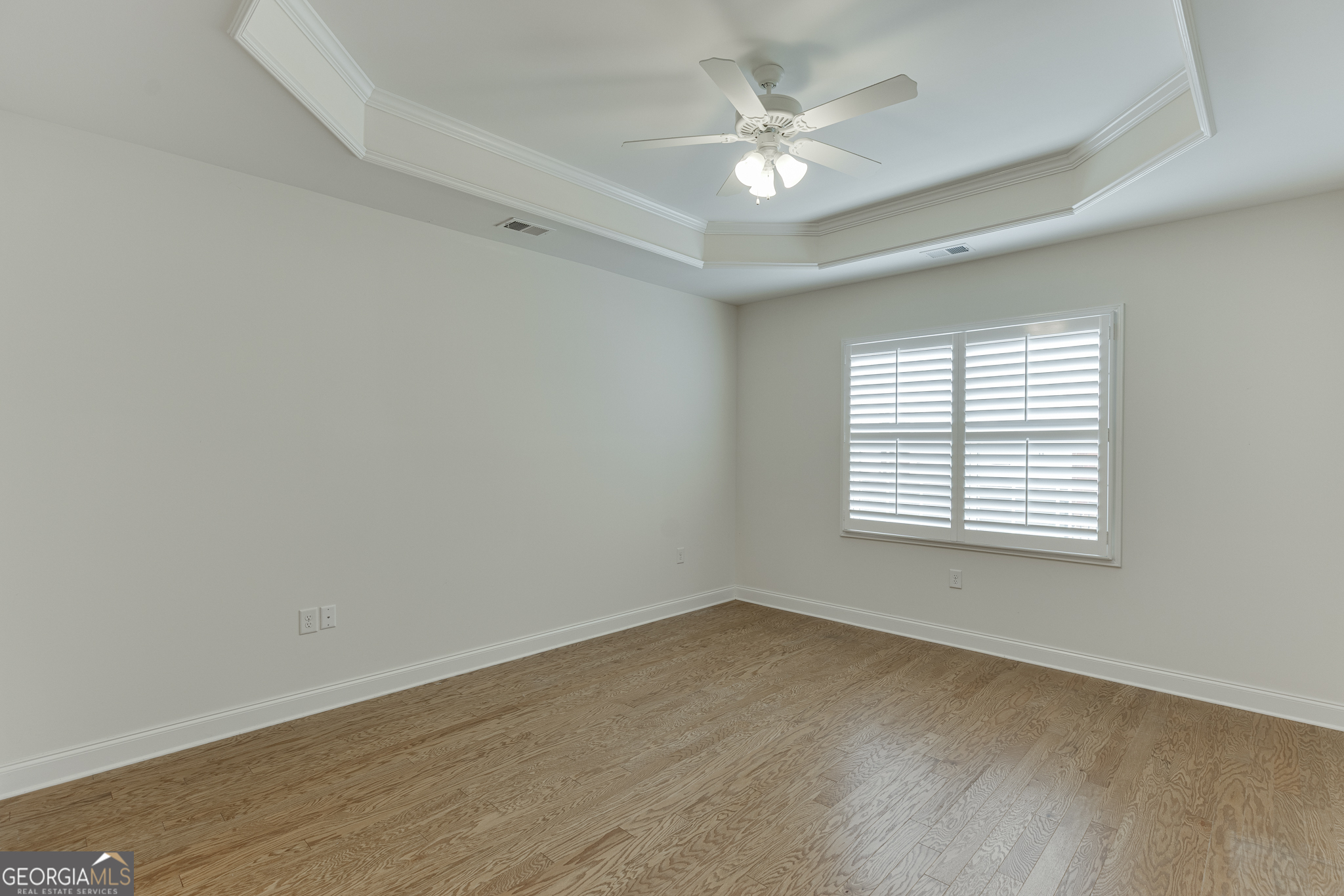 3765 Ridgehurst Drive Buford, GA 30518 - Photo 26 of 44 Large primary suite with tray ceiling and hardwood flooring.