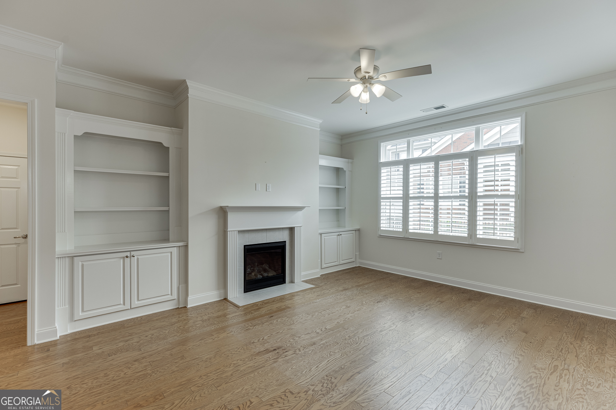 3765 Ridgehurst Drive Buford, GA 30518 - Photo 8 of 44 Spacious family room with fireplace, built-ins, and hardwood flooring.