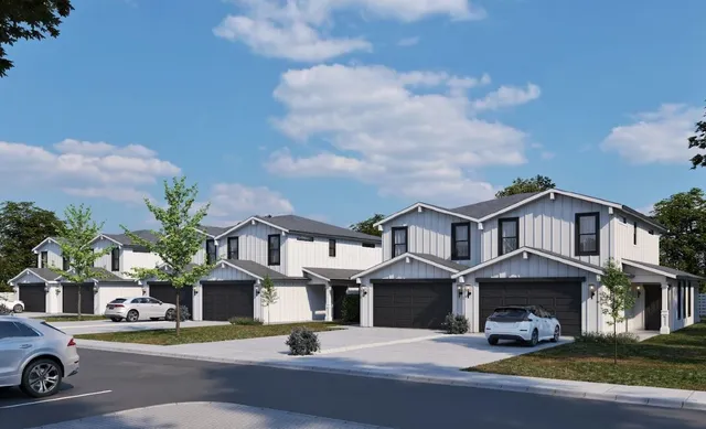 a front view of a residential apartment building with yard and parking