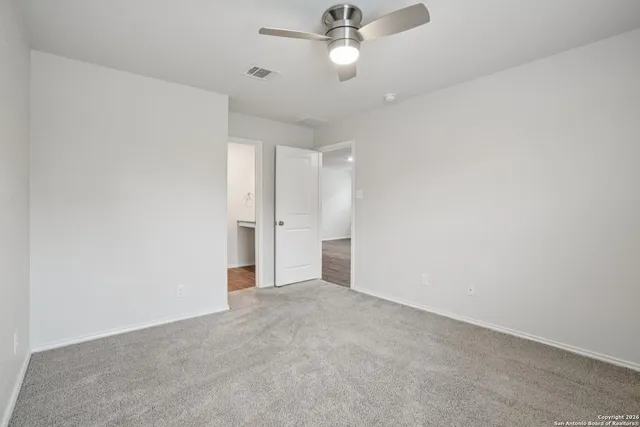 an empty room with a ceiling fan and a fan