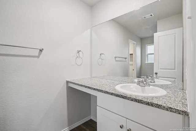 a bathroom with a granite countertop sink and a mirror