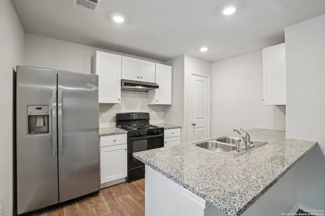 a kitchen with stainless steel appliances granite countertop a sink stove and refrigerator