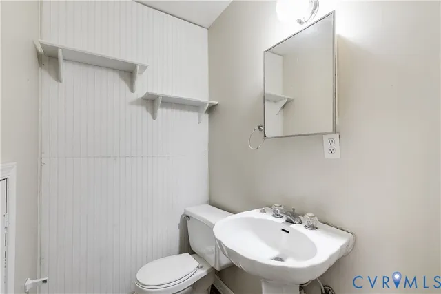 a bathroom with a sink a toilet and mirror