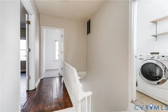 a view of a hallway with wooden floor and cabinets