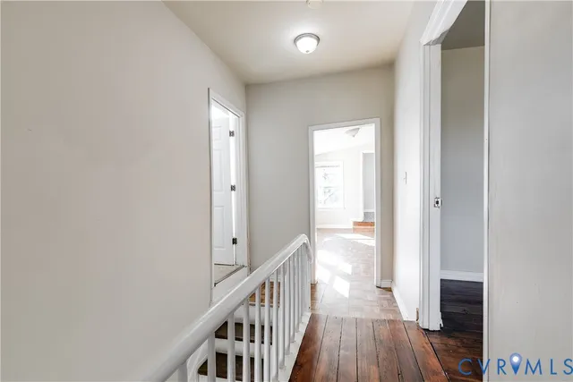 a view of a hallway with wooden floor and staircase