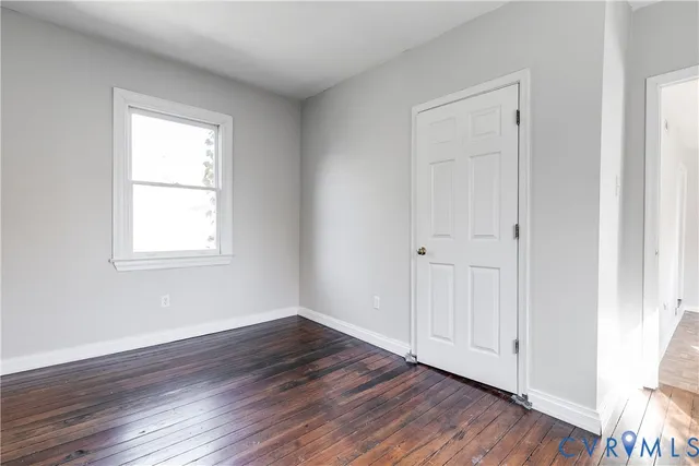 a view of a small space with wooden floor and a window