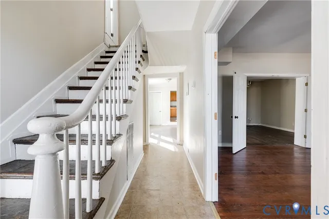 a view of staircase with wooden floor and white walls