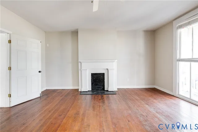 wooden floor fireplace and windows in an empty room