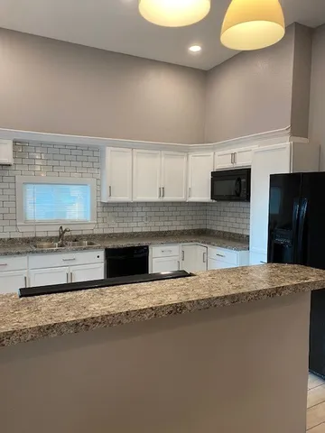 a kitchen with stainless steel appliances granite countertop a sink a stove and a refrigerator