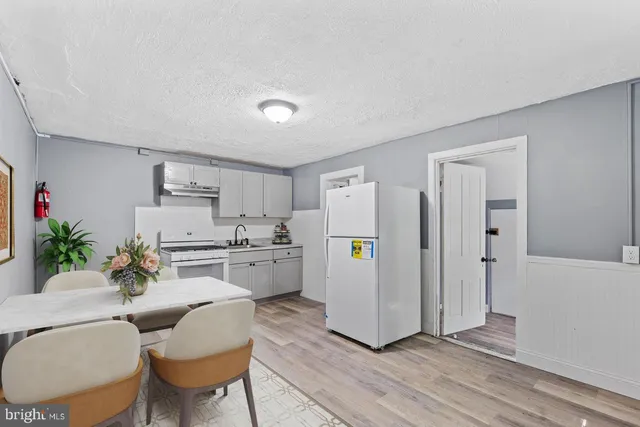 a living room with stainless steel appliances kitchen island furniture and wooden floor