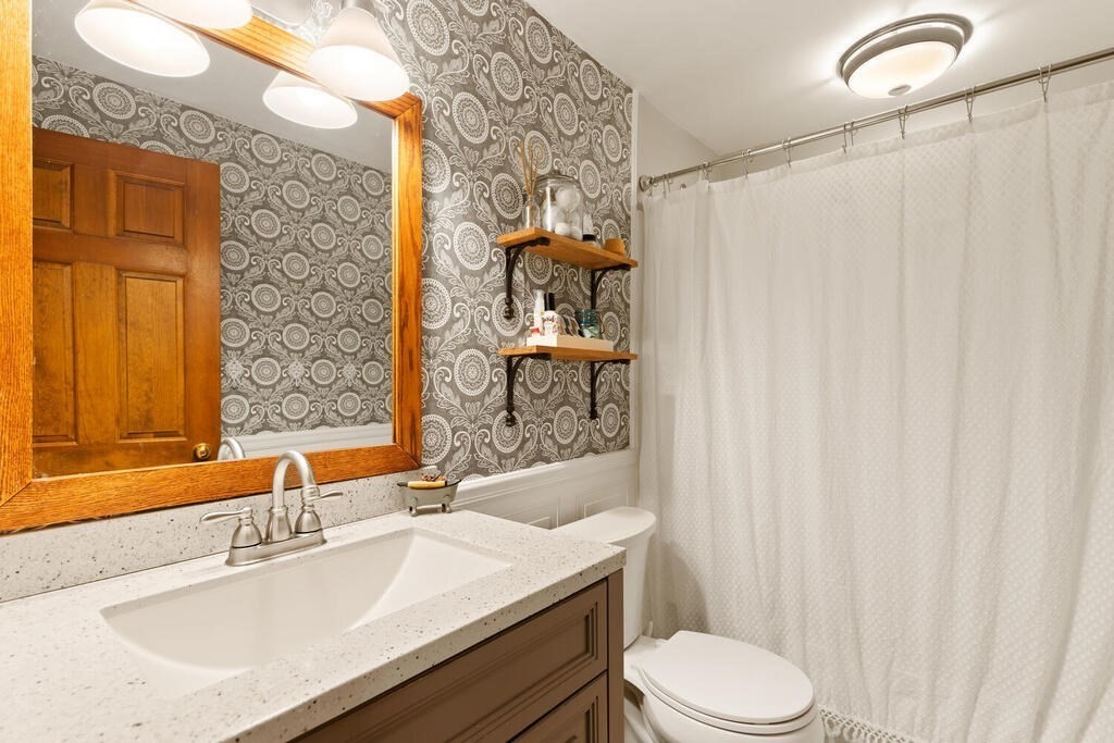 1 Meadowbrook Road Hudson, MA 01749 - Photo 22 of 36 a bathroom with a sink a toilet and shower curtain