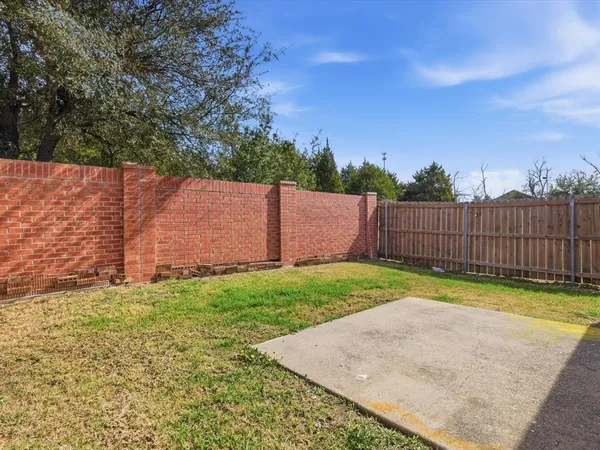 a view of backyard with wooden fence