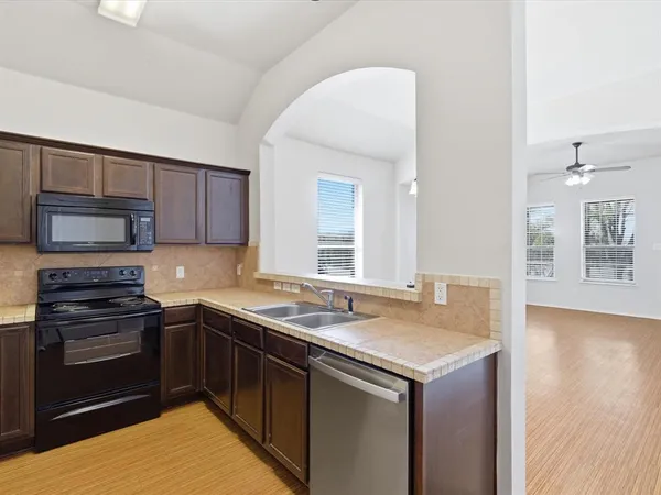 a kitchen with stainless steel appliances granite countertop a sink stove and microwave