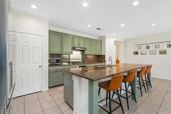 a kitchen with stainless steel appliances granite countertop a stove a sink and a refrigerator