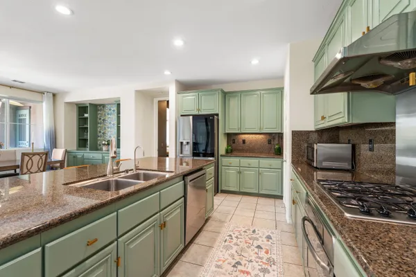 a kitchen with stainless steel appliances granite countertop a sink and a stove